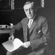 An archival photo of Woodrow Wilson sitting at a desk