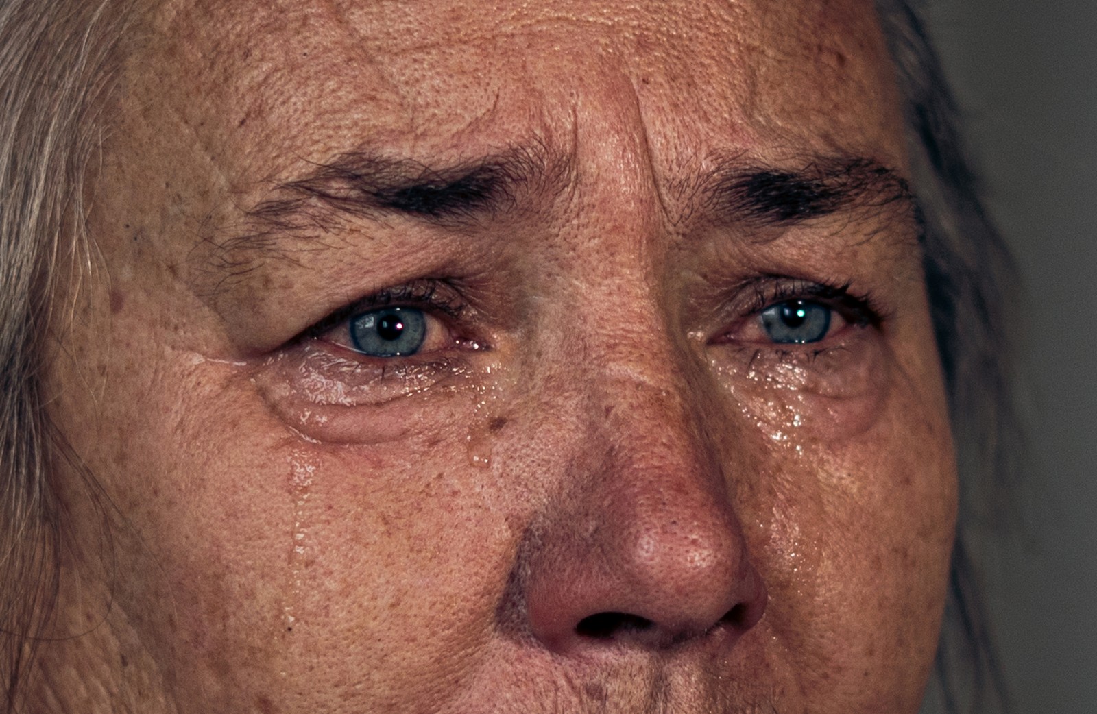 A close view of the face of a crying woman.