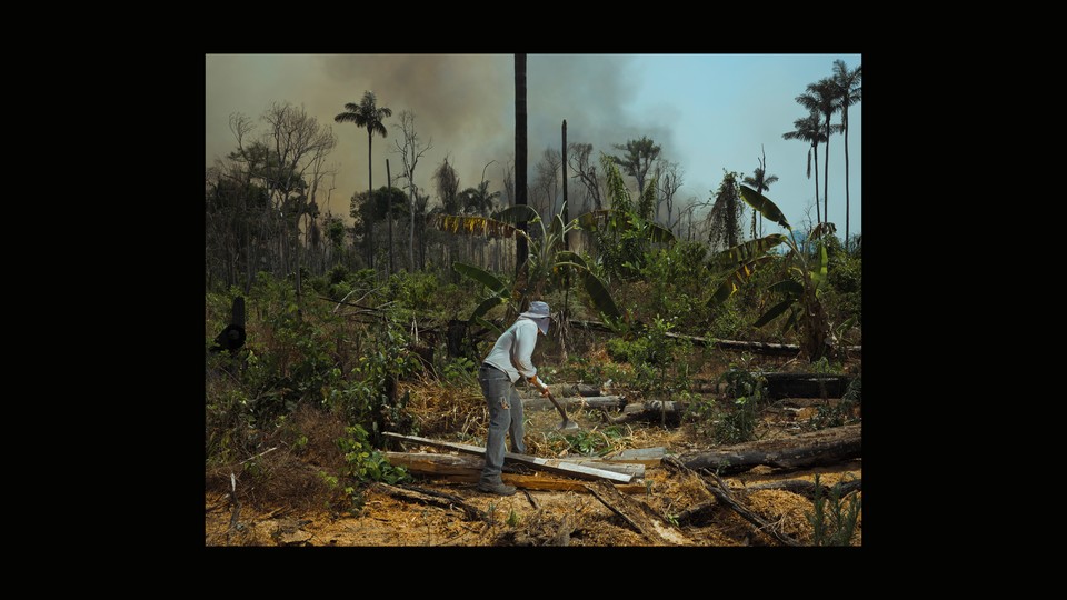 BRAZIL. 2019. Edmar, a worker on a small farm in the Victoria settlement, clears away brush in an effort to contain fires.
