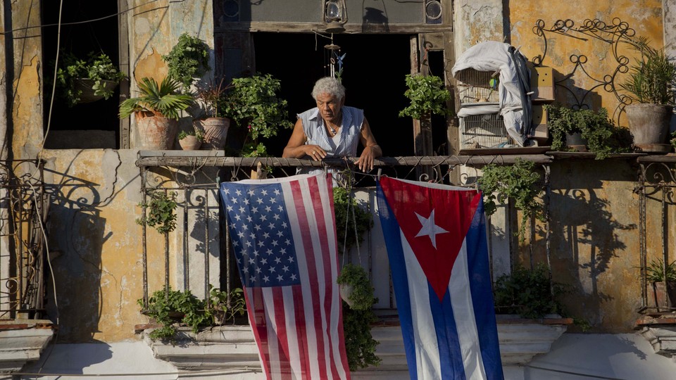Javier Yanez stands on his balcony decorated with U.S. and Cuban flags in Old Havana, Cuba.