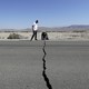 Two men examine a crack in Highway 178 caused by the recent earthquakes in Ridgecrest, California.