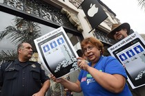 Workers holding signs and protesting in front of an Apple store