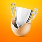 Photo-illustration of a silver trophy popping out of an egg shell