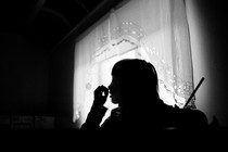 A black and white photo of a girl studying at home.