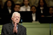 Jimmy Carter stands before a Sunday-school class, clasping his hands together.