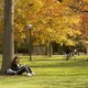 Young female student sitting under tree on campus
