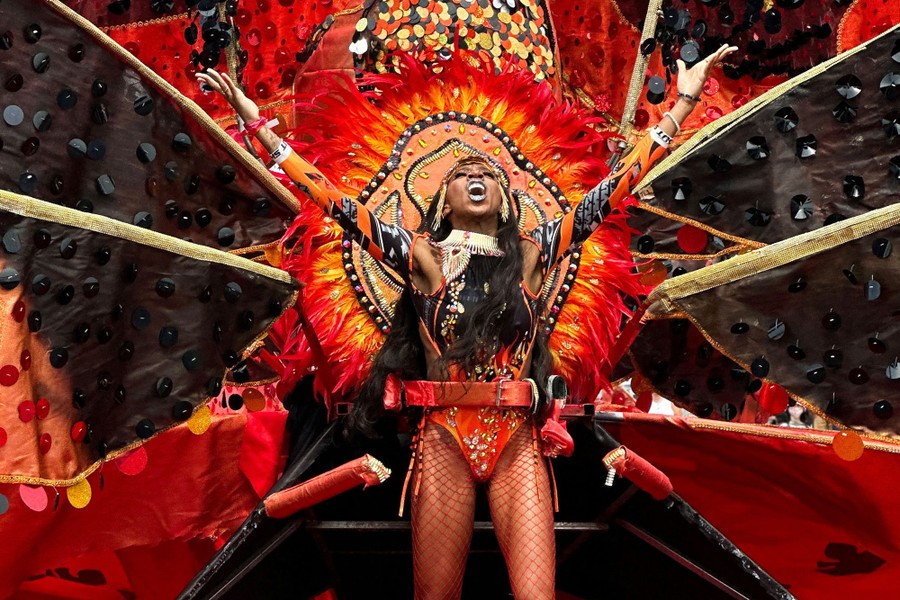 A performer appears in a large and colorful costume during a parade.
