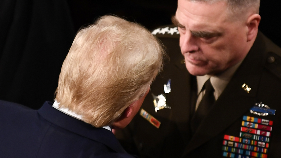 The back of Trump's head as he converses with General Mark Milley