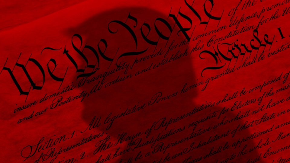 A red-tinted United States constitution with the shadow of Donald Trump's bust over it