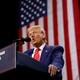 Photo of Donald Trump giving a speech at a podium with an American flag hanging behind him