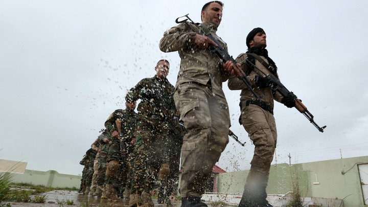 Christians volunteers, who have joined the Kurdish Peshmerga fighters, take part in a training session by coalition forces in a training camp.