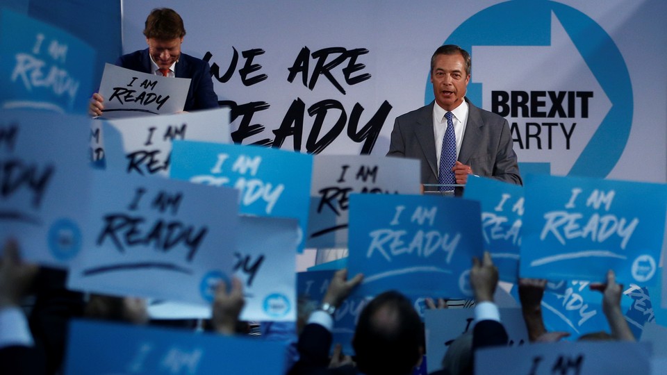 Nigel Farage speaks to Brexit Party supporters who hold signs reading "I am ready."