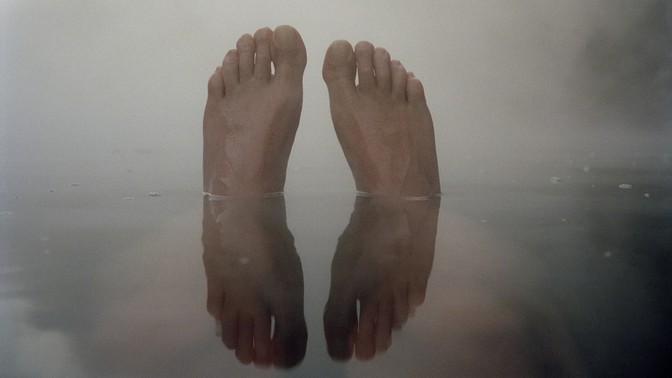 Reflection of feet half out of water