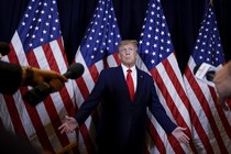 Picture showing Donald Trump, in front of reporters, shrugging.