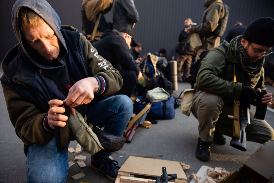 About a dozen people work on loading ammunition and preparing newly-received rifles.