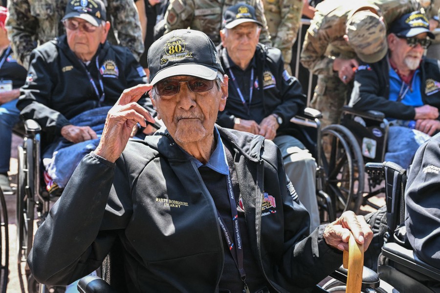 A veteran, seated among others in wheelchairs, salutes.