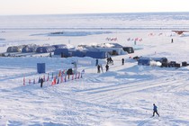 A photo of an ice camp with multiple tents and flags from many nations