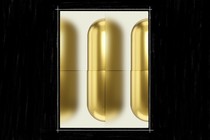 An image of three gold-colored pills, slightly blurred