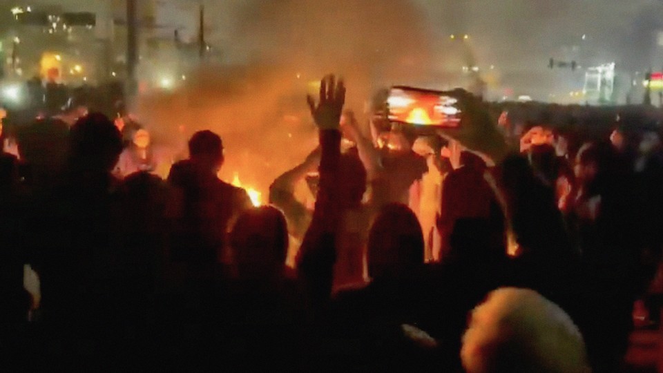 A frame grab from footage circulating on social media showing protesters dancing and cheering around a bonfire in Tehran, Iran