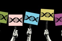 Hands hold up picket signs with DNA on them