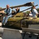 A man sits on a Russian missile displayed for Ukrainians in central Kyiv.
