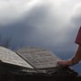 Two people touch the Ten Commandments Monument