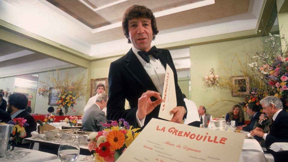 A diner's-eye view of a menu and waiter