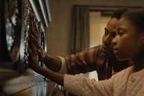 Two children touch a piano in “The Piano Lesson”