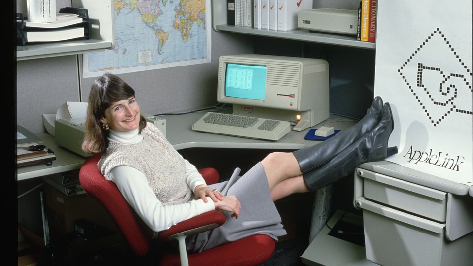 An Apple employee poses with a personal computer in 1986.