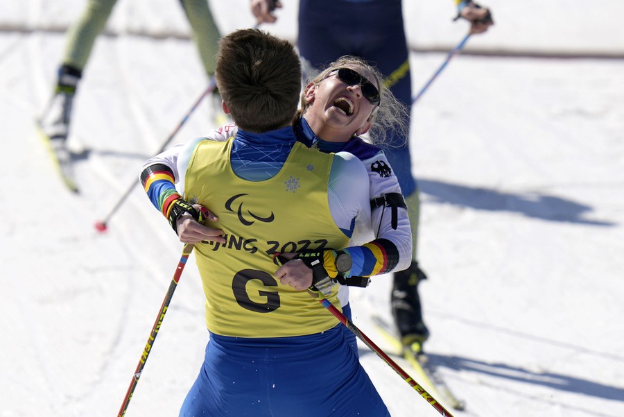 A skier celebrates a win by hugging her guide after a race.