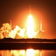 NASA's new moon rocket, the Space Launch System, lifts off from the launchpad, its engines blazing bright