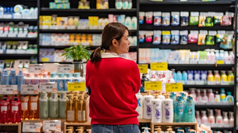 A woman looking overwhelmed by products in a Chinese grocery store.