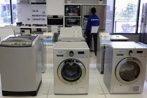 Samsung washing machines are seen as an employee inspects refrigerators at a Samsung display store in Johannesburg, October 3, 2013