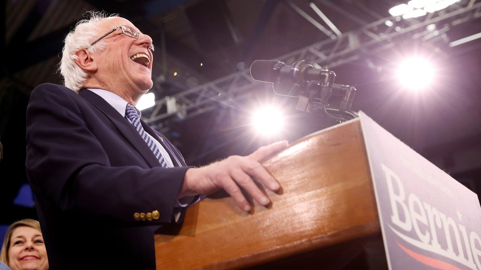 Bernie Sanders laughing at a podium