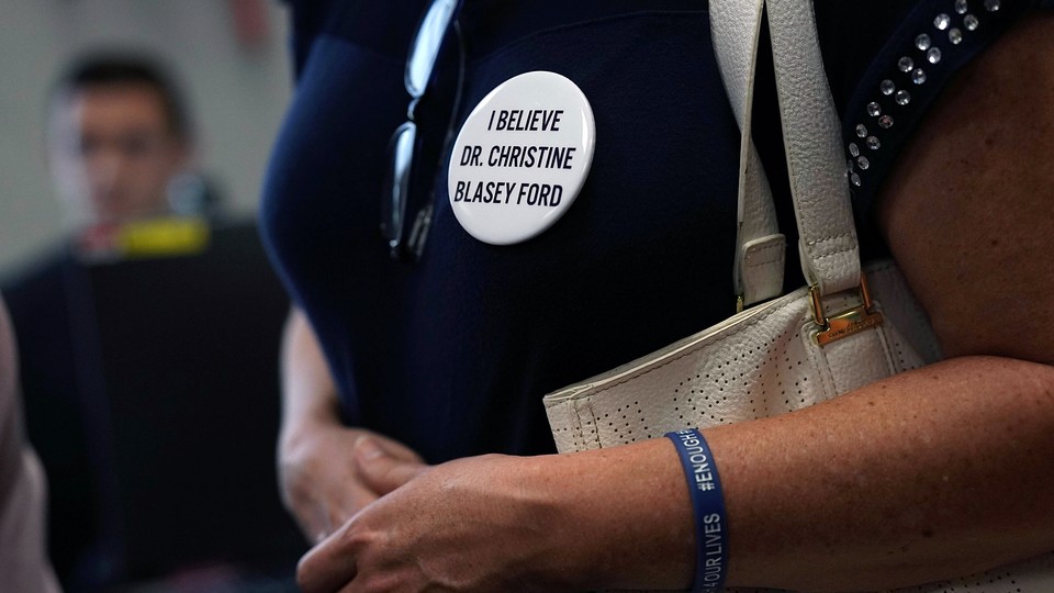 An activist wears a button in support of Christine Blasey Ford, who has accused Brett Kavanaugh of sexual assault at a high-school party more than 35 years ago.