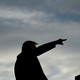 Silhouette of Donald Trump speaking at a lectern with his arm in the air