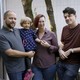 Three adults posing with a young child
