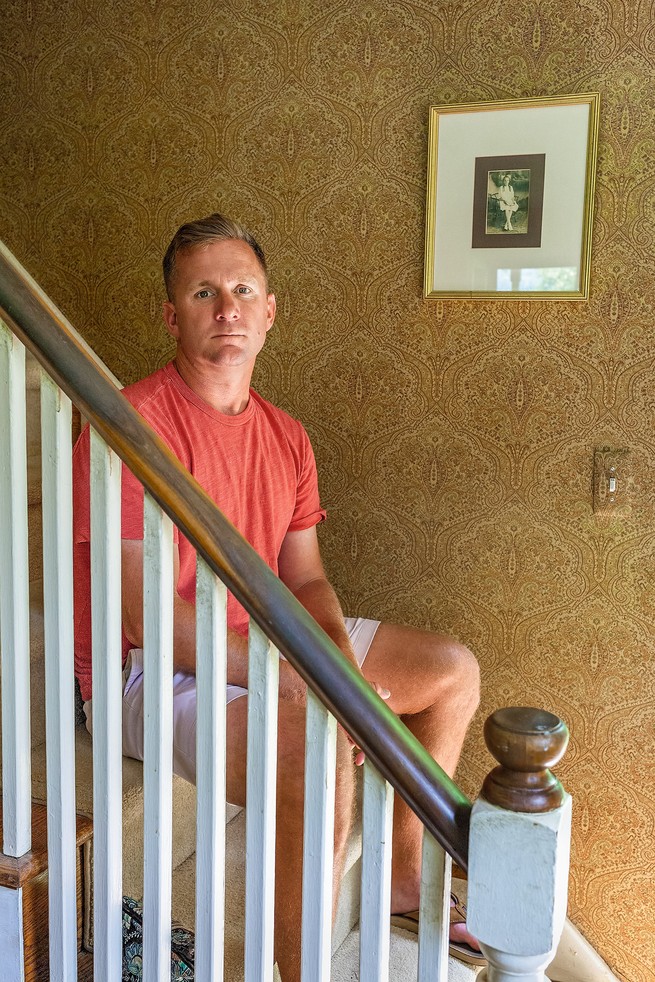 Jeff McIlvaine seated on stairs behind a bannister