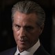 Gavin Newsom seen in a close up portrait with dark, dramatic lighting