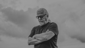 a man looking down with sky behind him