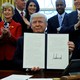 President Donald Trump holds a signed copy of an executive order