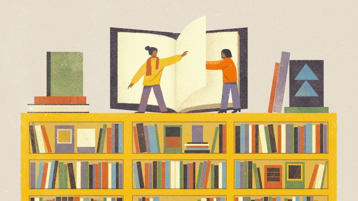 Two women stand on top of a huge bookshelf, helping each other turn the page of a large book