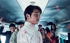 A still from the movie "Train to Busan" showing a bloodied man on a train with other passengers
