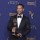 John Legend holding his Emmy award