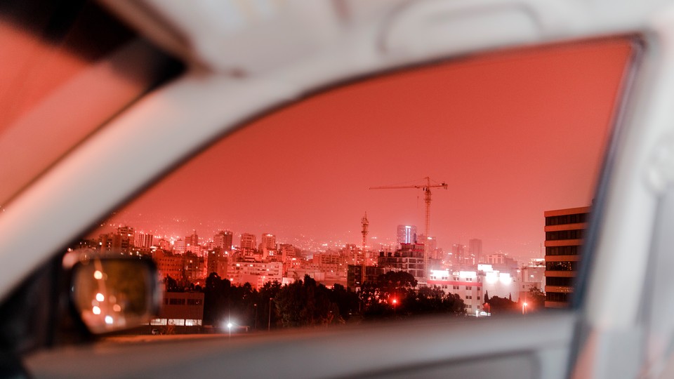 Red-tinted Beirut captured through a car window