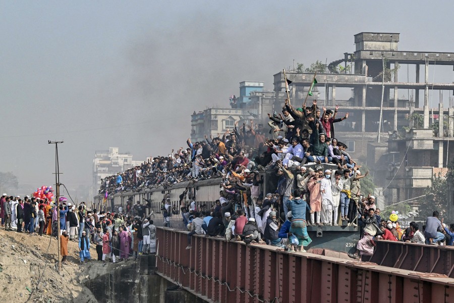 Hundreds of people ride in and on a train.