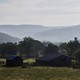 A barn in the foreground with mountains in the background