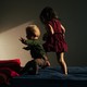 Two children playing on a bed