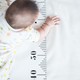 Baby crawling over growth measuring tape