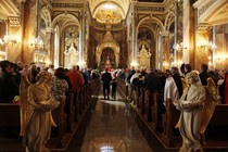 The inside of a Basilica filled with ornate and religious arches, paintings, and statues